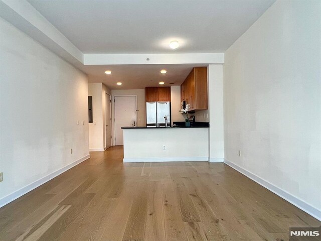 800 12th St Unit 207, Palisades Park, NJ 07650 - kitchen featuring freestanding refrigerator, dark countertops, wood finished floors, recessed lighting, and brown cabinetry