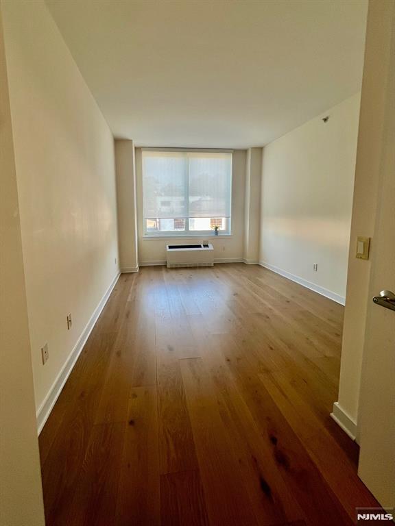 800 12th St Unit 207, Palisades Park, NJ 07650 - unfurnished room featuring wood finished floors, a baseboard radiator, and baseboards