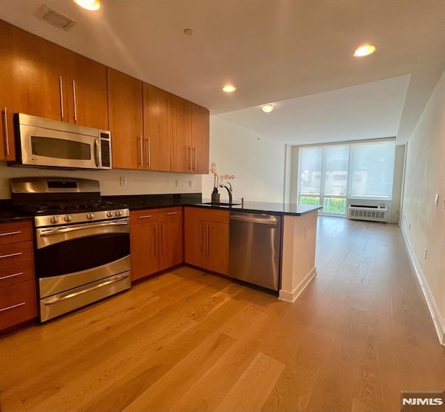 800 12th St Unit 207, Palisades Park, NJ 07650 - kitchen featuring appliances with stainless steel finishes, light wood-style floors, dark countertops, a peninsula, and recessed lighting
