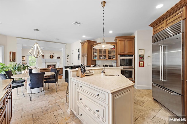 6 Lauren Pond Ct, Demarest, NJ 07627 - kitchen with appliances with stainless steel finishes, a sink, stone tile flooring, brown cabinetry, and decorative backsplash