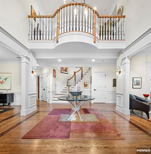 6 Lauren Pond Ct, Demarest, NJ 07627 - foyer entrance featuring ornate columns, a towering ceiling, stairs, a decorative wall, and wood finished floors