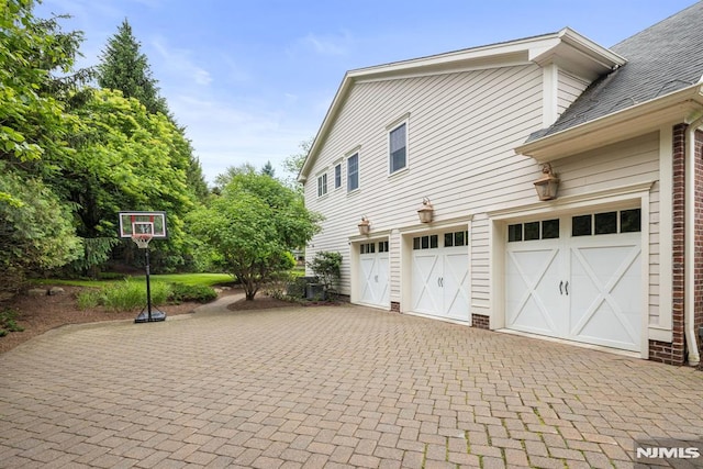 6 Lauren Pond Ct, Demarest, NJ 07627 - view of side of home featuring decorative driveway, brick siding, and an attached garage