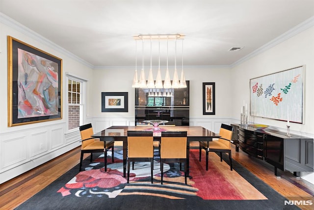 6 Lauren Pond Ct, Demarest, NJ 07627 - dining area featuring wood finished floors, crown molding, bar area, a wainscoted wall, and a decorative wall