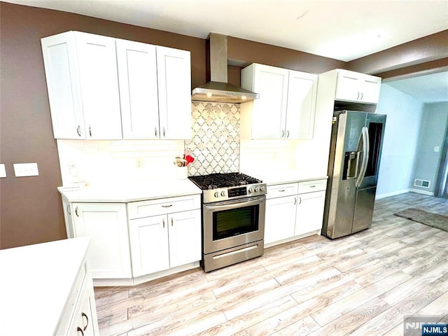194 Elm Ave, Teaneck, NJ 07666 - kitchen featuring appliances with stainless steel finishes, wall chimney range hood, light wood finished floors, backsplash, and light countertops