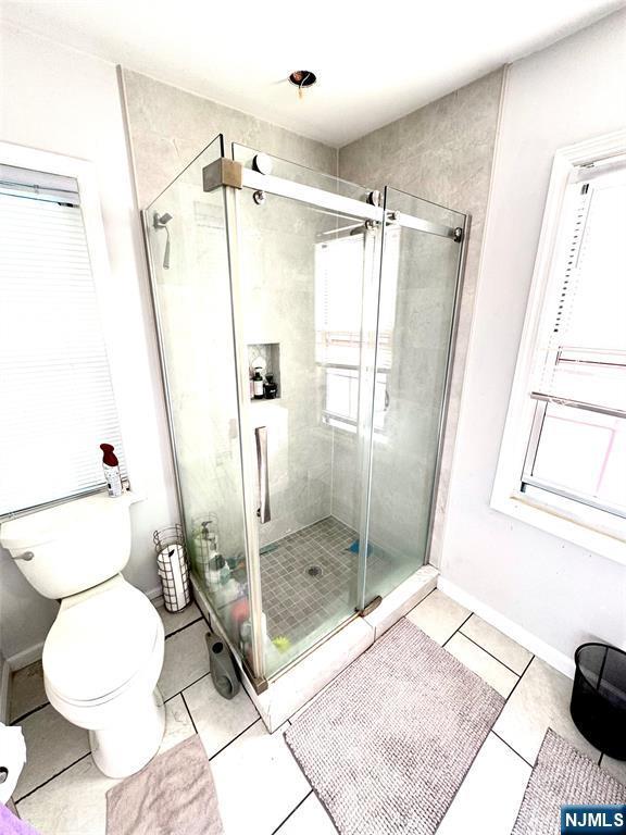 194 Elm Ave, Teaneck, NJ 07666 - bathroom with toilet, a shower stall, tile patterned flooring, and healthy amount of natural light