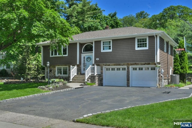 126 Darrow Dr, North Haledon, NJ 07508 - split foyer home with stone siding, asphalt driveway, a garage, central AC, and a chimney