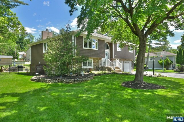 126 Darrow Dr, North Haledon, NJ 07508 - raised ranch with an attached garage, a chimney, stone siding, and driveway