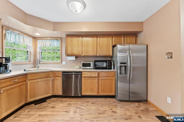 41 Sycamore Ave, Hillsdale, NJ 07642 - kitchen featuring appliances with stainless steel finishes, a sink, light countertops, and light wood-type flooring