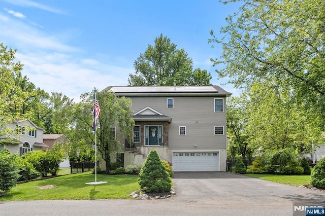 41 Sycamore Ave, Hillsdale, NJ 07642 - view of front facade featuring an attached garage, roof mounted solar panels, asphalt driveway, and brick siding