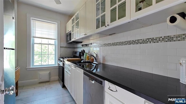 275 Engle St Unit G4, Englewood, NJ 07631 - kitchen with stainless steel appliances, dark countertops, baseboards, white cabinetry, and a sink