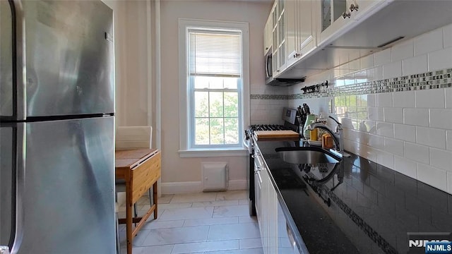 275 Engle St Unit G4, Englewood, NJ 07631 - kitchen with freestanding refrigerator, a sink, baseboards, white cabinets, and range with gas stovetop