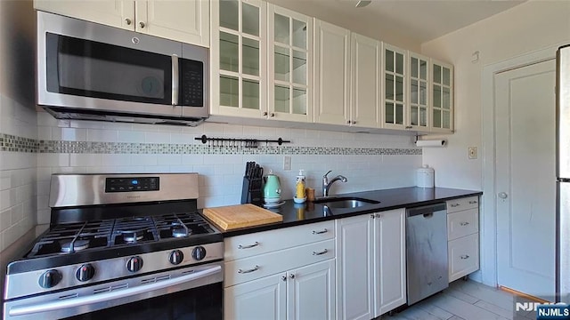 275 Engle St Unit G4, Englewood, NJ 07631 - kitchen with stainless steel appliances, a sink, decorative backsplash, and glass insert cabinets