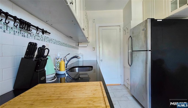 275 Engle St Unit G4, Englewood, NJ 07631 - kitchen featuring freestanding refrigerator, a sink, light marble finish flooring, glass insert cabinets, and white cabinetry