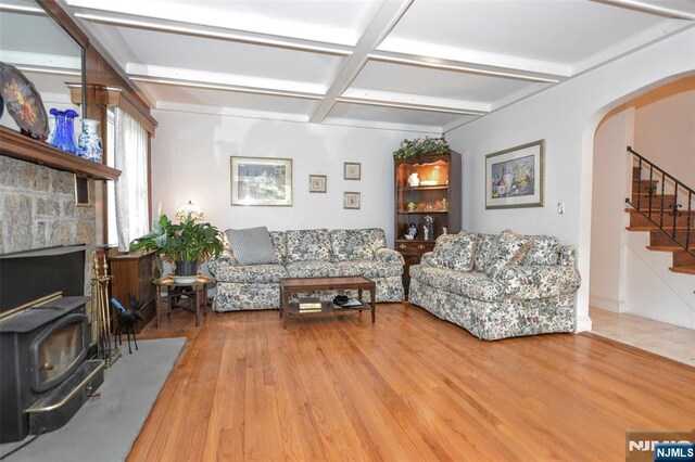 76 Spring Valley Rd, Montvale, NJ 07645 - living room featuring coffered ceiling, stairs, arched walkways, a wood stove, and wood finished floors