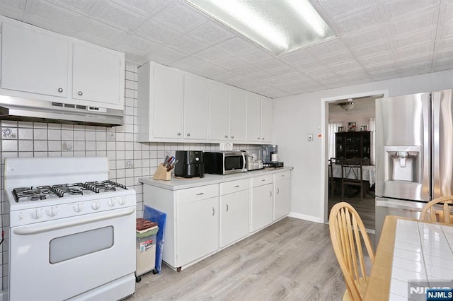 328-330 Hoover Ave, Bloomfield, NJ 07003 - kitchen featuring appliances with stainless steel finishes, under cabinet range hood, an ornate ceiling, light countertops, and light wood-style floors
