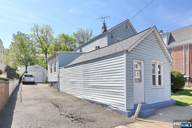 328-330 Hoover Ave, Bloomfield, NJ 07003 - view of side of home featuring a detached garage, an outbuilding, entry steps, a shingled roof, and a chimney