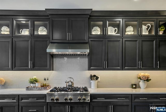 15 Meadowbrook Rd, Upper Saddle River, NJ 07458 - kitchen featuring range hood, stainless steel gas cooktop, backsplash, and glass insert cabinets