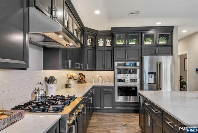 15 Meadowbrook Rd, Upper Saddle River, NJ 07458 - kitchen with appliances with stainless steel finishes, under cabinet range hood, wood finished floors, tasteful backsplash, and recessed lighting