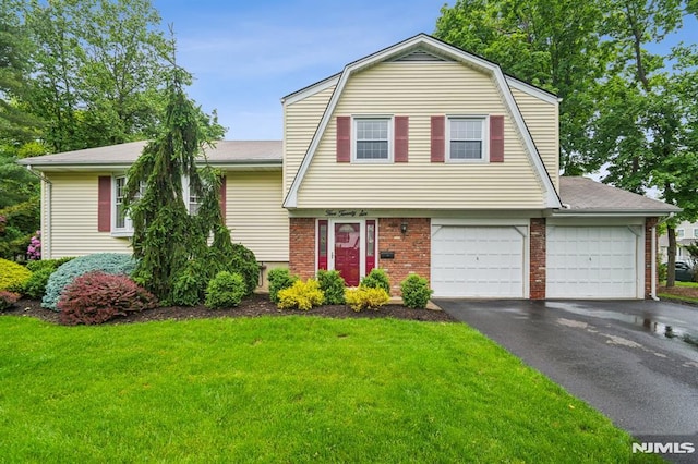 526 Cleveland Ave, River Vale, NJ 07675 - colonial inspired home with brick siding, asphalt driveway, a front yard, a gambrel roof, and roof with shingles