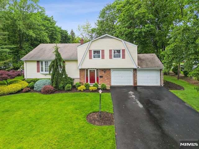526 Cleveland Ave, River Vale, NJ 07675 - colonial inspired home featuring a gambrel roof, brick siding, a front yard, asphalt driveway, and a chimney