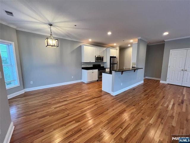 107 Hawthorne Ave Unit D, Park Ridge, NJ 07656 - kitchen with appliances with stainless steel finishes, wood finished floors, dark countertops, a breakfast bar, and ornamental molding