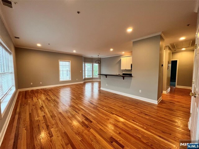 107 Hawthorne Ave Unit D, Park Ridge, NJ 07656 - unfurnished living room with wood finished floors, ornamental molding, baseboards, recessed lighting, and a chandelier