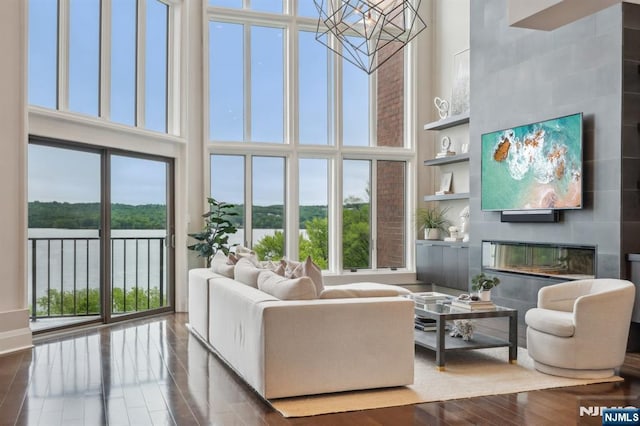 1360 Hamburg Tpke Unit 702, Wayne, NJ 07470 - living room with a high ceiling, a water view, wood finished floors, a chandelier, and a tiled fireplace