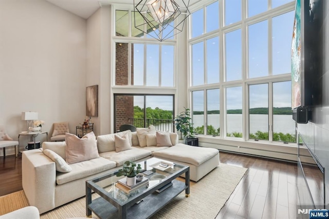 1360 Hamburg Tpke Unit 702, Wayne, NJ 07470 - living area featuring a high ceiling, a chandelier, wood finished floors, a baseboard radiator, and a water view