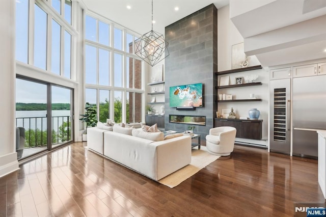 1360 Hamburg Tpke Unit 702, Wayne, NJ 07470 - living room with a towering ceiling, dark wood-style floors, a water view, recessed lighting, and a large fireplace