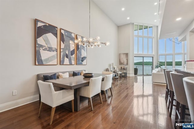 1360 Hamburg Tpke Unit 702, Wayne, NJ 07470 - dining space with floor to ceiling windows, a towering ceiling, wood finished floors, baseboards, and a chandelier