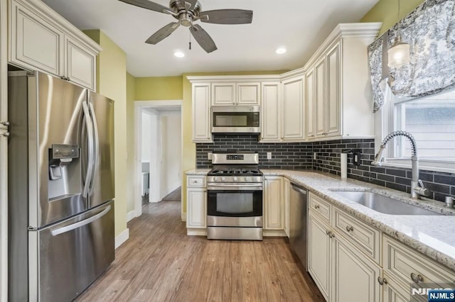 21 Albert Ave, Fair Lawn, NJ 07410 - kitchen featuring appliances with stainless steel finishes, a sink, cream cabinets, tasteful backsplash, and a ceiling fan