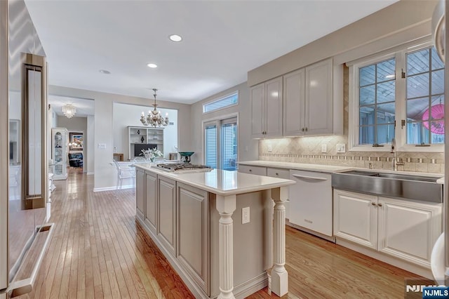  - kitchen featuring dishwasher, a chandelier, a sink, light countertops, and recessed lighting