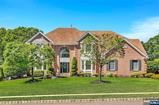  - view of front facade with a front lawn and brick siding