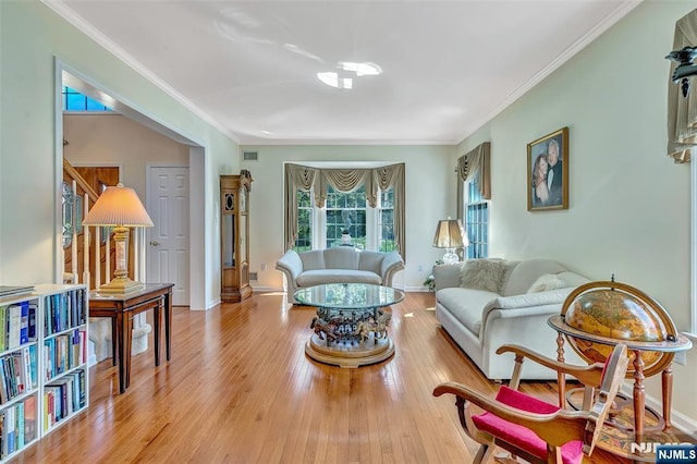  - living room with wood finished floors, ornamental molding, and baseboards
