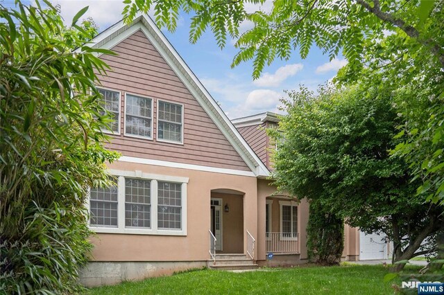 40 Upsala Ct, East Orange, NJ 07017 - traditional-style home featuring a front lawn, covered porch, and stucco siding