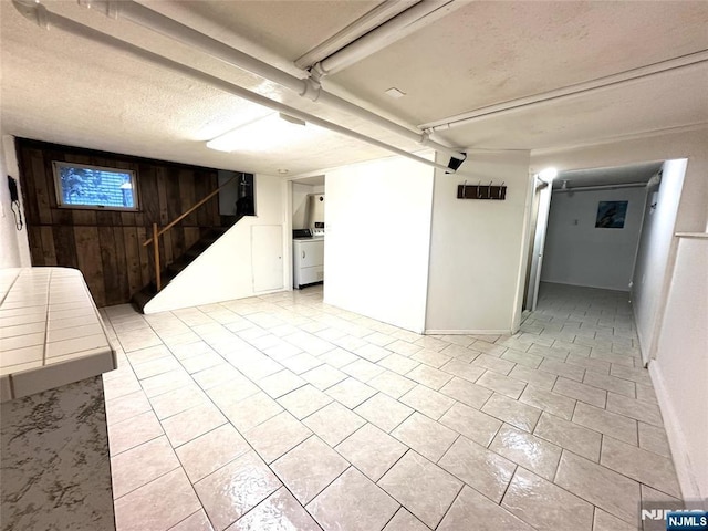 128 Oak Ridge Ave, Nutley, NJ 07110 - finished below grade area with light tile patterned floors, washer / dryer, a textured ceiling, and stairway