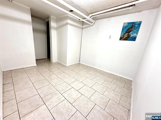 128 Oak Ridge Ave, Nutley, NJ 07110 - basement featuring light tile patterned floors, a textured ceiling, and baseboards