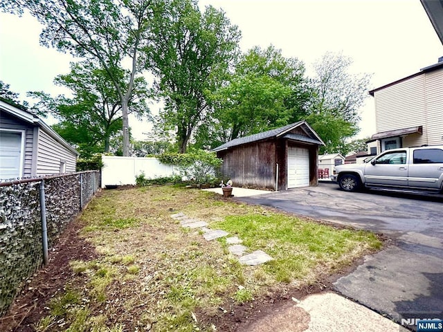 128 Oak Ridge Ave, Nutley, NJ 07110 - view of yard with an outbuilding, a garage, and asphalt driveway