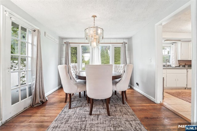 26 Howard Pl, Waldwick, NJ 07463 - dining area featuring a textured ceiling, wood finished floors, baseboards, and a chandelier