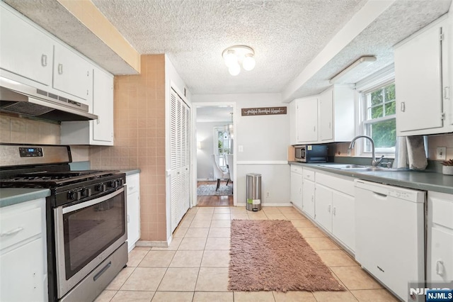 26 Howard Pl, Waldwick, NJ 07463 - kitchen with stainless steel appliances, under cabinet range hood, a sink, a textured ceiling, and light tile patterned floors