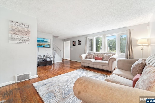 26 Howard Pl, Waldwick, NJ 07463 - living room featuring hardwood / wood-style flooring, a textured ceiling, stairs, and baseboards