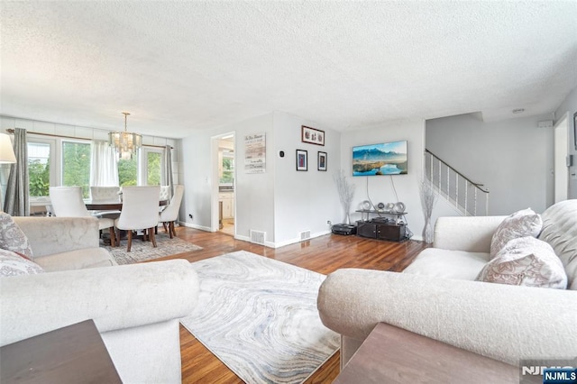 26 Howard Pl, Waldwick, NJ 07463 - living room featuring a textured ceiling, wood finished floors, stairway, a chandelier, and baseboards