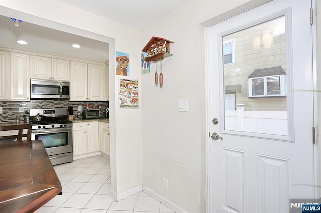 1154 Summit Ave, Teaneck, NJ 07666 - kitchen with appliances with stainless steel finishes, backsplash, light tile patterned floors, recessed lighting, and baseboards