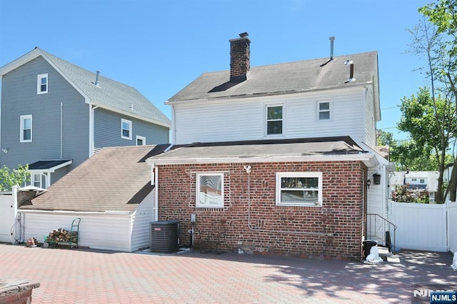 1154 Summit Ave, Teaneck, NJ 07666 - back of property featuring central air condition unit, brick siding, and a chimney
