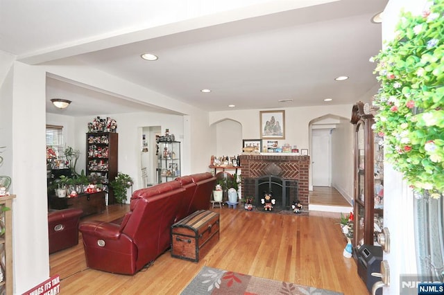 1154 Summit Ave, Teaneck, NJ 07666 - living area with wood finished floors, a brick fireplace, arched walkways, and recessed lighting