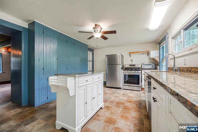 58 Maple Ave, Montville Township, NJ 07058 - kitchen with stainless steel appliances, a ceiling fan, stone finish floors, white cabinets, and wooden walls
