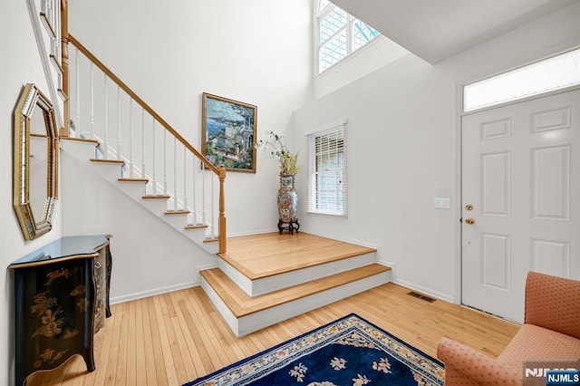 8 Pine Lake Ter Unit T008, River Vale, NJ 07675 - entryway featuring stairway, healthy amount of natural light, wood-type flooring, a high ceiling, and baseboards