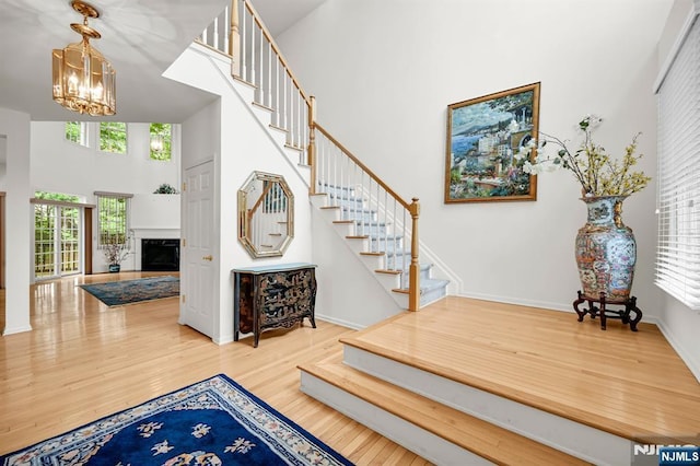 8 Pine Lake Ter Unit T008, River Vale, NJ 07675 - stairs featuring a towering ceiling, a chandelier, wood finished floors, a fireplace, and baseboards