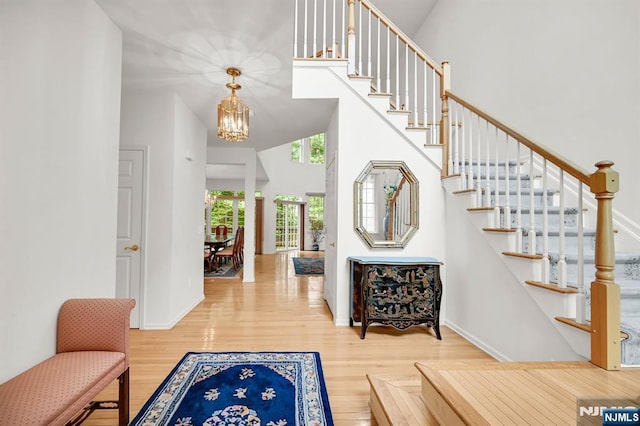 8 Pine Lake Ter Unit T008, River Vale, NJ 07675 - entrance foyer with a chandelier, wood finished floors, stairs, a towering ceiling, and baseboards