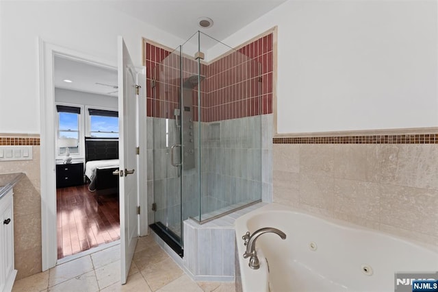 52 Myrtle Ave Unit B, Edgewater, NJ 07020 - bathroom featuring tile walls, connected bathroom, a stall shower, a tub with jets, and vanity
